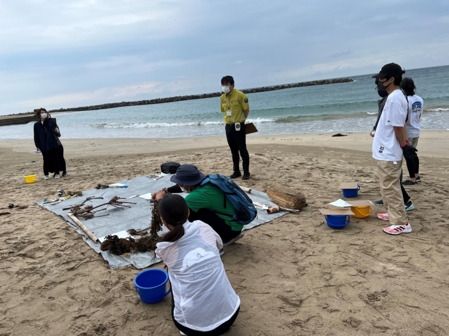 漂着物をレジャーシートに集めている写真