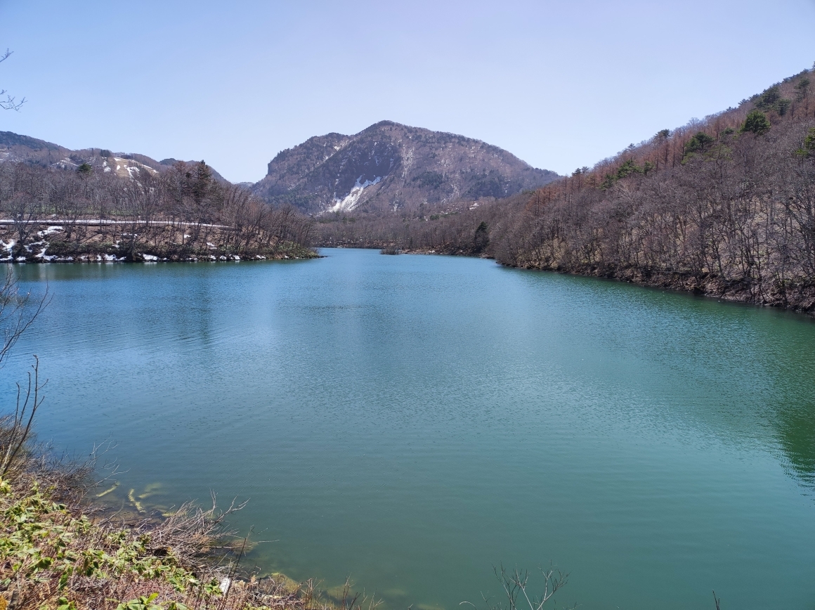 琵琶池を望む。周辺の斜面に残雪がある。
