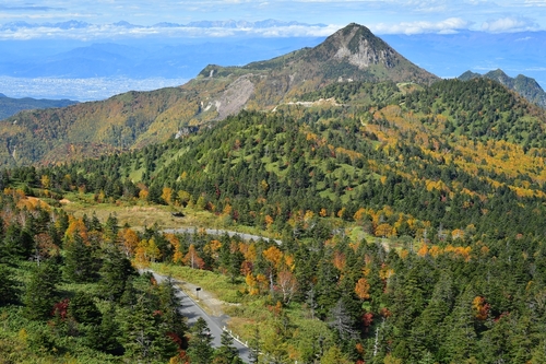 のぞきからの紅葉。中景に笠ヶ岳、遠景に北アルプスが見える。