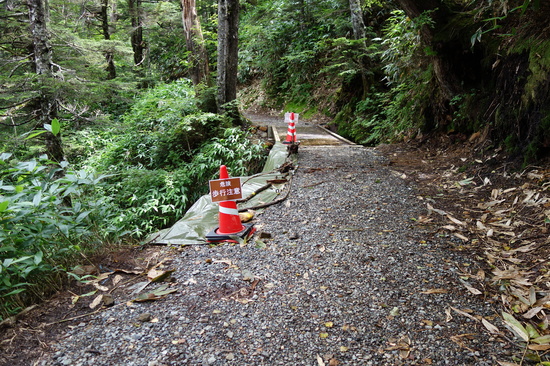 歩道の谷側斜面の崩落。通行注意。